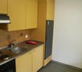 kitchen with yellow cabinets, stainless steel sink, countertop, gas stove, refrigerator, built-in light