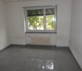 Empty room, white walls, tiled floor, white window, window blinds, radiator, power outlet
