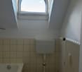 Bathroom with bathtub, toilet, arch window, tiled walls, radiator