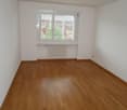 empty room, hardwood floor, white walls, large window, white radiator