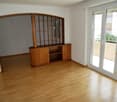 Empty room with wooden floor, wooden shelf with sliding glass doors leading to a balcony