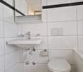 white tiles, sink, toilet, mirror, black accents