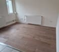 empty room, wooden floors, white walls, radiator, electrical outlets, window