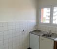Tiled walls, stainless steel sink, white cabinets, tile flooring