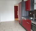 modern kitchen with white tiled floor, modern red cabinets, stainless steel sink, stainless steel dishwasher