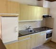 small kitchen, wooden cupboards, fridge, sink, oven, 4 burner stove, chimney hood