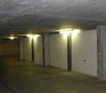 underground parking with large white garage doors, fluorescent lights on ceiling