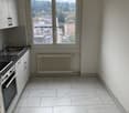 white tiles, white cabinets, kitchen sink, oven, white window with a city view