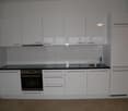 White cabinets, black countertops, stainless steel sink, oven and dishwasher. Modern and clean kitchen
