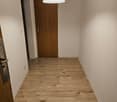 empty room, wooden floor, white walls, brown wooden door, power outlet, white ceiling light
