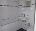 white tiles, bathtub, sink, mirror, toilet, shower head