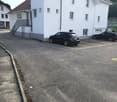 Empty parking lot with marked parking spaces in front of the building.