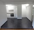 empty kitchen with white cabinets, black tiled floor, built-in oven