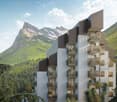 Multi-story apartment building with balconies overlooking a mountainous landscape with snow-capped peaks, lush green forests, and a scenic backdrop.