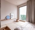 Bedroom with bed, bedside table, shelf, window with view to outside, wall-mounted mirror, woven basket.