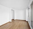 empty room, white walls, wooden floor, sliding glass doors to balcony