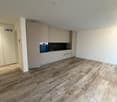Large room, with wooden floors, tall white ceilings, white walls, fully equipped kitchen, dishwasher, built-in oven and sink