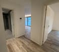empty hallway, tiled floor, white walls, two doors, shower room