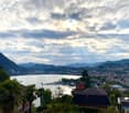 Aerial view of a city and a lake with mountains in the background and a cloudy sky