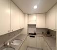 clean kitchen with white cabinets, granite countertops, modern appliances including dishwasher and washing machine