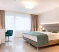 bed, pillows, blanket, desk, chair, lamp, TV, curtain, tiled floor, nightstand
