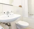 modern bathroom with sink, toilet, bathtub and mirror