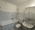 white tiled floor, white bathtub, white toilet, white sink, mirror cabinet