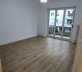 Empty room, hardwood floors, white walls, sliding glass doors, balcony, large windows