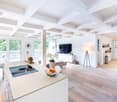 Open kitchen, dining area, living room, balcony, modern design, wooden floors, white walls, large windows, chandelier, TV, couch, flowers, lamps, cabinets, baskets, vases