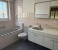 white tiled walls, bathtub, toilet, sink, shower head