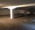 concrete floor, white walls, high ceiling, three windows