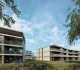 Modern multi-story apartment buildings with balconies, surrounded by landscaped grounds and trees