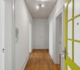 The image shows a long, narrow hallway with white walls, a wooden floor, and a white ceiling with recessed lighting. There is a white door on the left side and a yellow-framed window on the right side. The hallway appears to be part of a residential or co