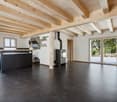 open room, black floors, large windows, kitchen island, fireplace