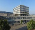 large building, multiple floors, large windows, parking lot