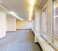 Empty room with white walls, white ceiling, carpeted floor, large windows