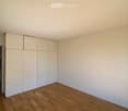empty room with wooden floor, white walls, large built-in wardrobes