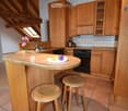 kitchen with wooden counter top, stove, cabinets, sink, stools, flower vase