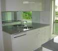 Modern kitchen, granite countertops, stainless steel double sink, dishwasher, cabinets, full length mirror, balcony view
