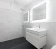 modern bathroom, white tiles, black tiles on floor, glass shower enclosure, white vanity with sink, mirror with lighting