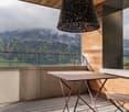 wooden floor, table, chair, pendant light, balcony, railings, stunning mountain view