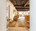 wooden flooring, wooden beams, white walls, traditional wooden furniture, hallway leading to a dining area