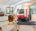 modern living room, white leather armchairs, black carpet, red sofa, large windows, wooden bookshelves, abstract painting