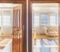 wooden door, wooden floor, white walls, white couch, white windows, rug, light