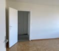 empty room, white walls, wooden floor, door leading to another room