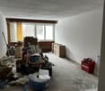 Empty room, white walls, storage boxes, large windows, toolbox, wires, floor cleaning tools