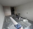 empty room, grey walls, grey floor, cabinets, buckets, plastic sheet, tools