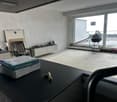 empty room, large windows, black table, boxes, tools, unfinished walls