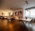 modern interior, wooden floor, dining table, chairs, artwork, shelves, lamps, window with curtains