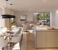 Dining room with large table, chairs, modern kitchen, living room with couch, balcony with view